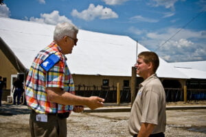 Justin Kilgus and tourist outside barns