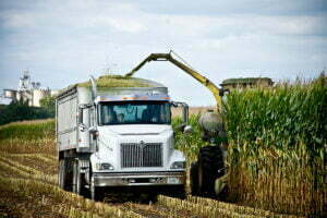 image of truck and tractor harvesting our corn