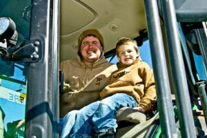 matt kilgus and son smiling in tractor
