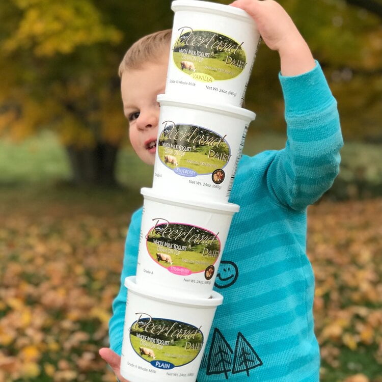 kid carrying a stack of yogurt