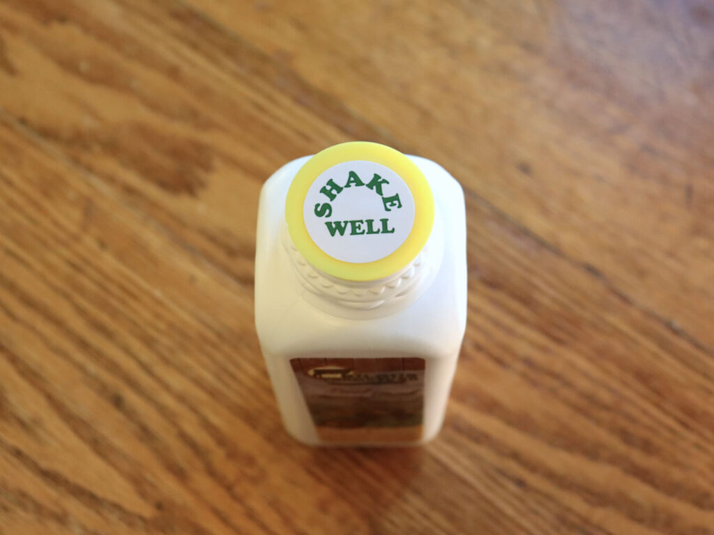 milk jug with cap that says "shake well"