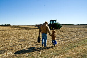 matt kilgus and young son holding hands in field