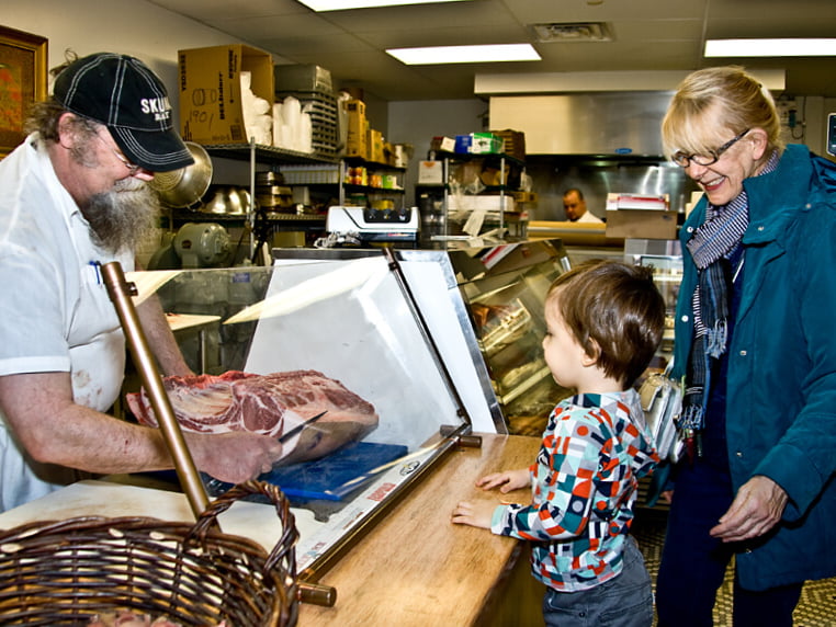 mom and son buy meat from butcher